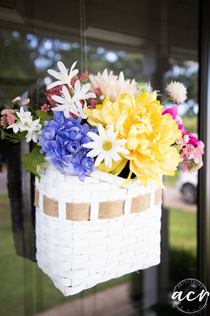 yellow and purple flowers in white basket