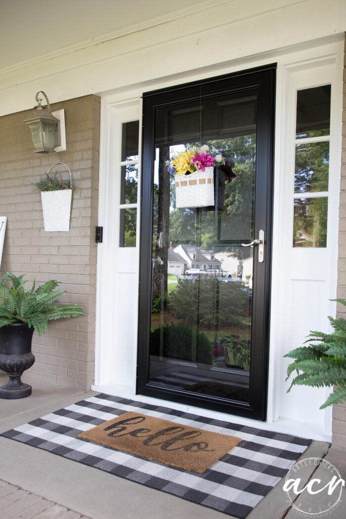 front porch with black and white with ferns and colorful basket