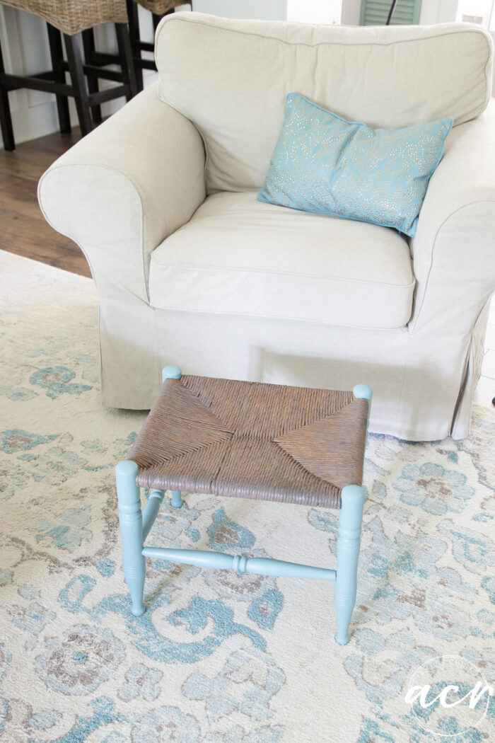 footstool in front of tan chair