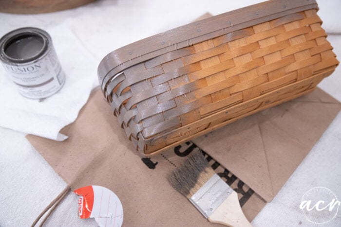 applying driftwood stain to the orange basket