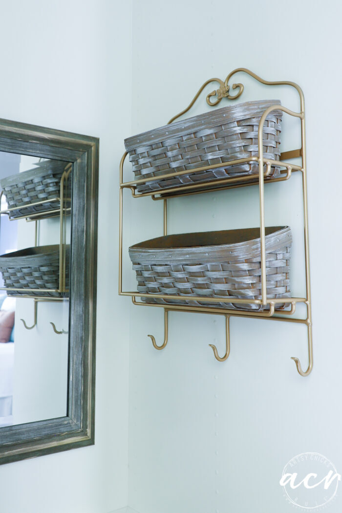 baskets and metal hanging on inside closet wall by mirror