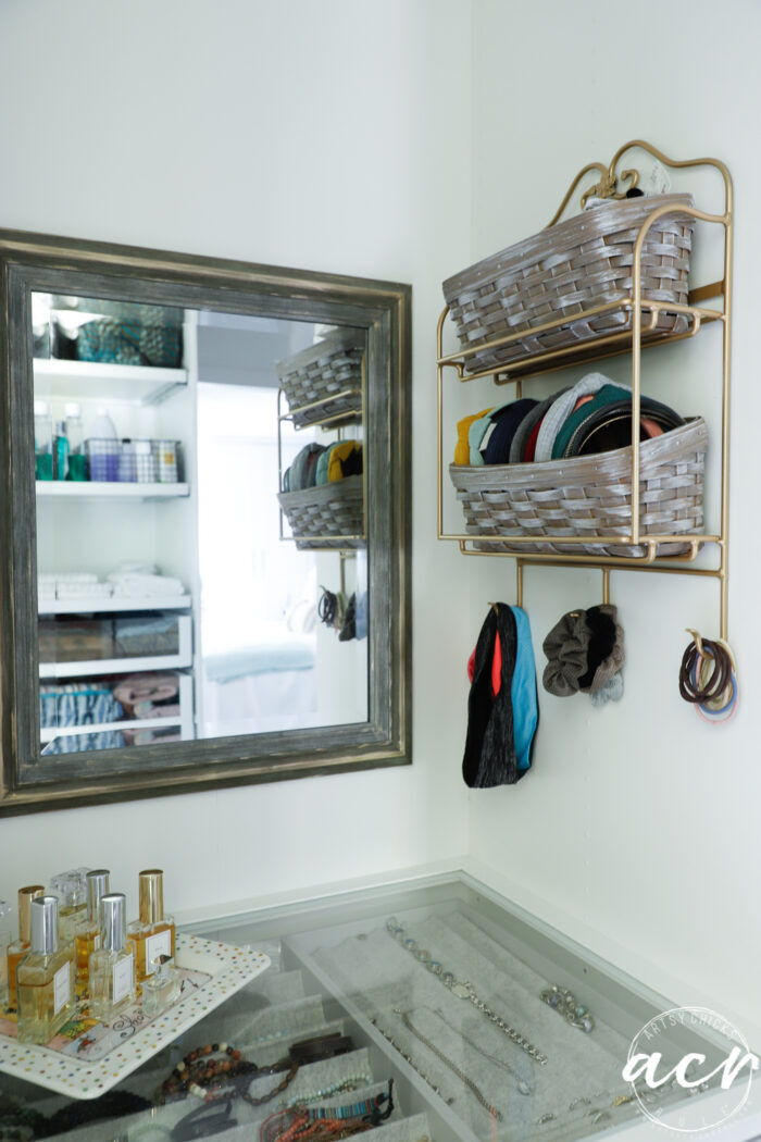 mirror, baskets hanging with perfume on tray