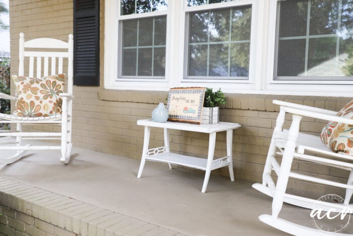 porch view with white table, pumpkin sign and 2 white rockers