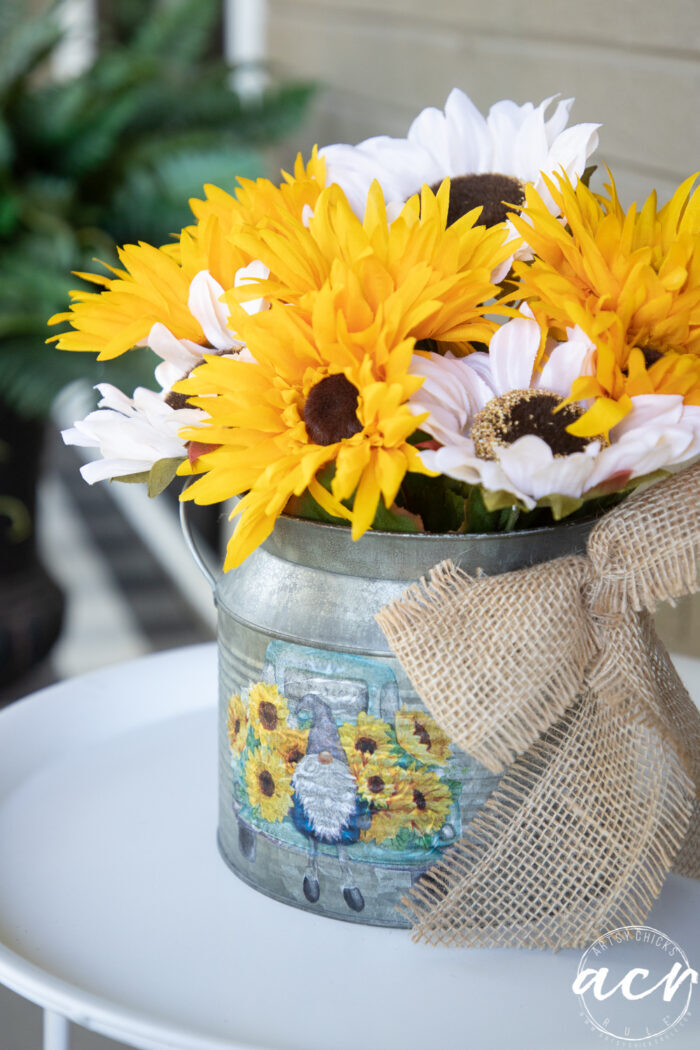 finished yellow and white sunflower arrangement inside tin on white table