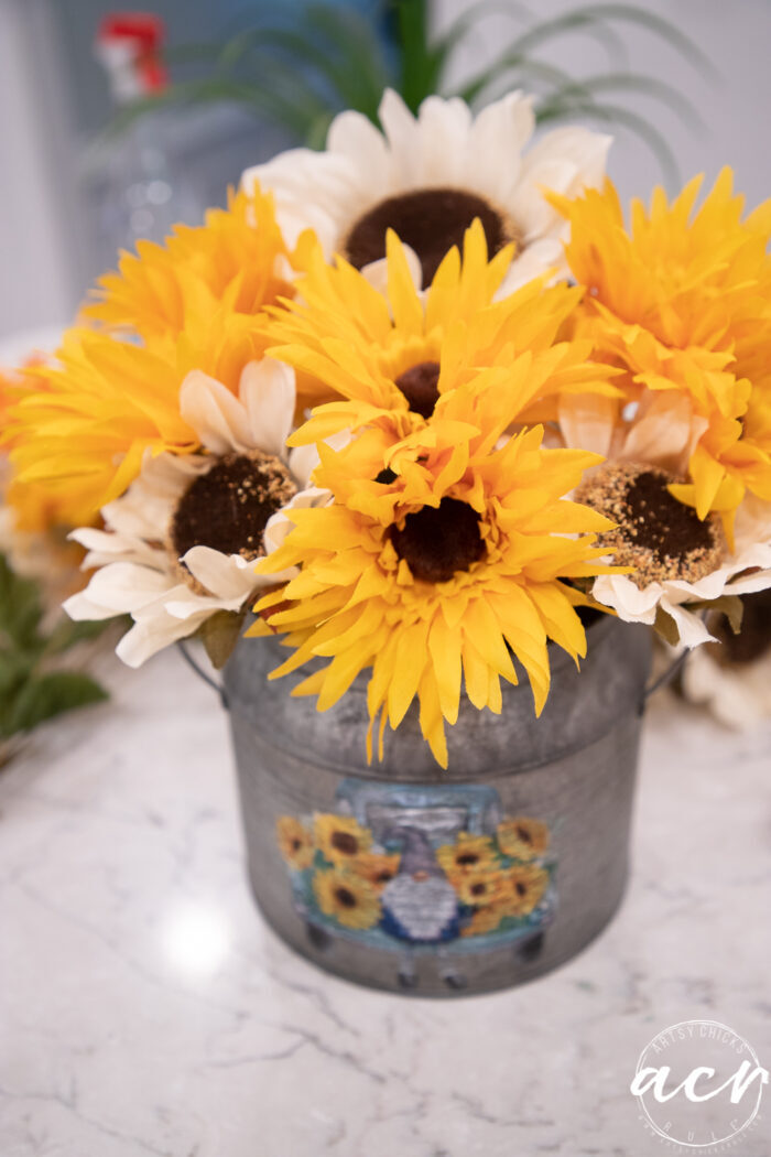 yellow and white sunflowers in tin on counter