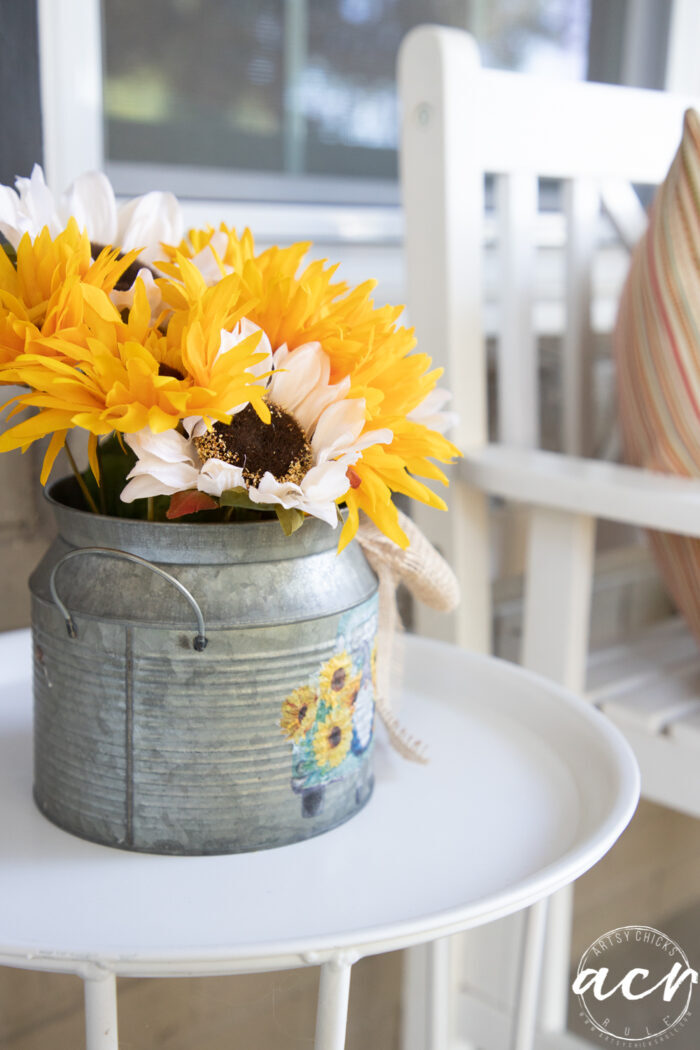 flowers in tin on white table on porch