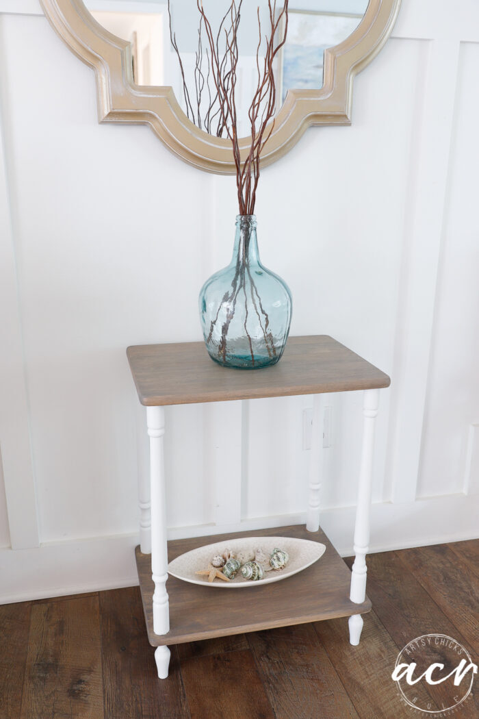 clear blue vase with sticks on top of driftwood table