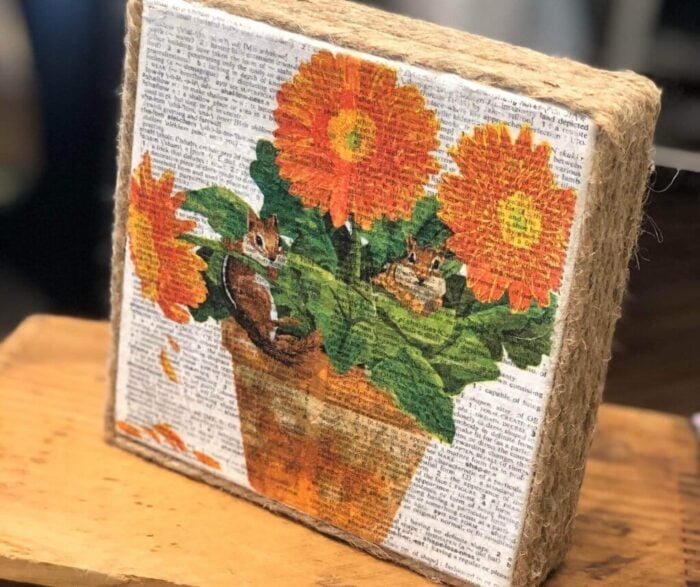 orange flowered napkin on canvas with rope frame