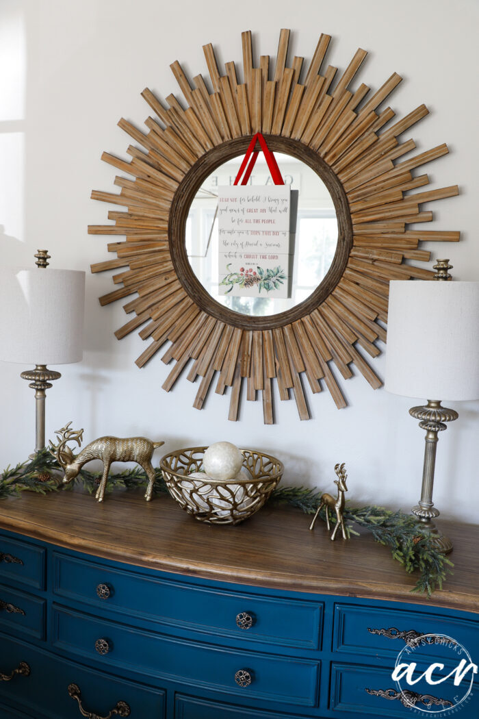 blue dresser with wood starburst mirror