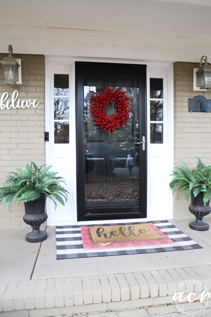 black front door with red berry wreath