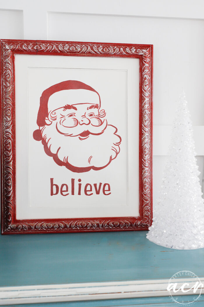 red framed painting of a red painted santa face