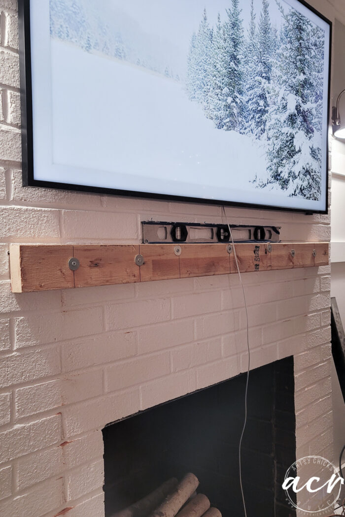 wood attached to brick fireplace to attach mantel to