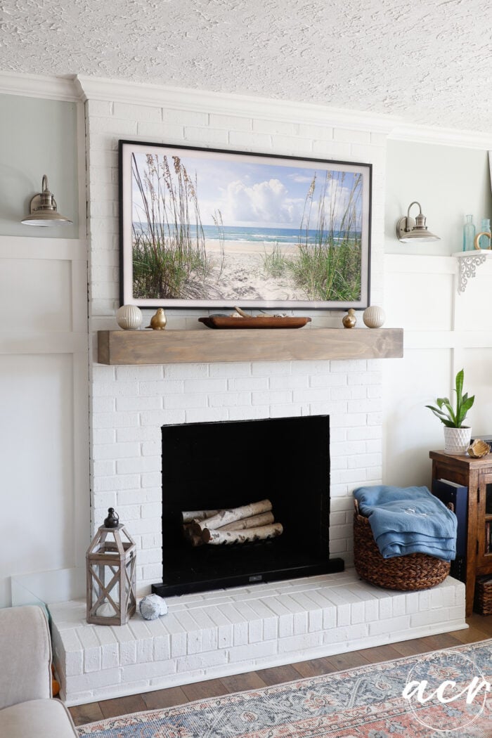driftwood colored block wood mantel with tv over top and fireplace below