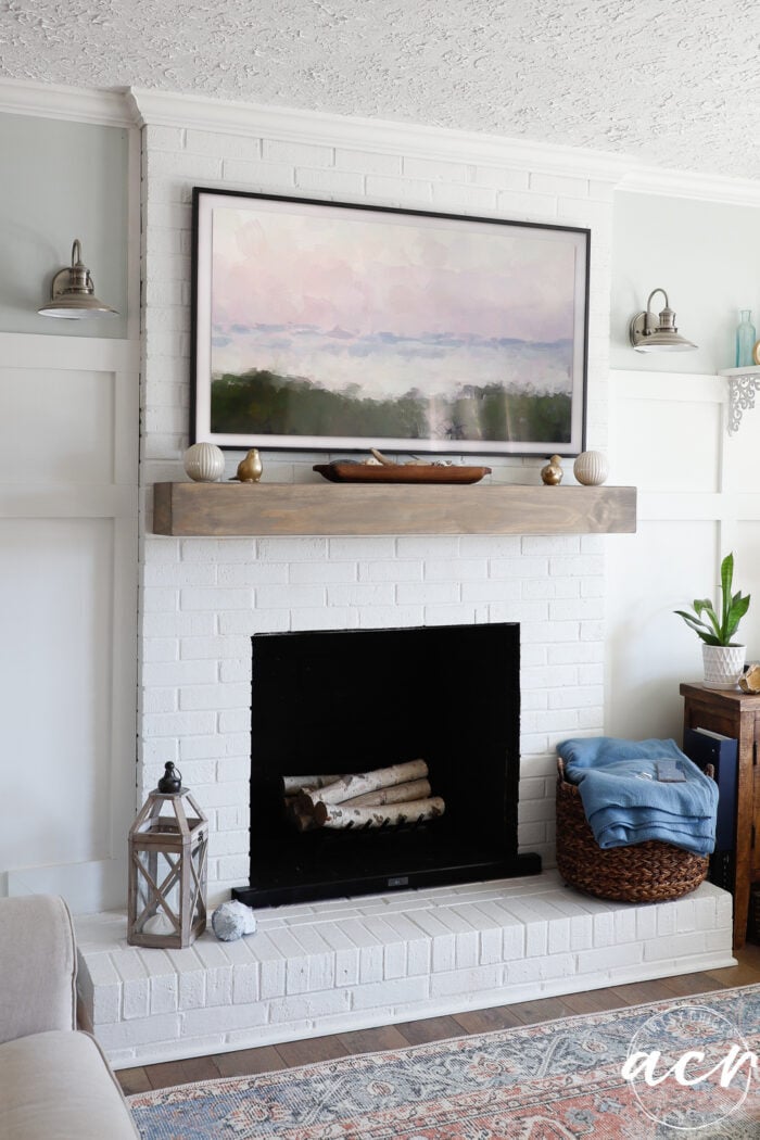 Frame TV with artwork over fireplace