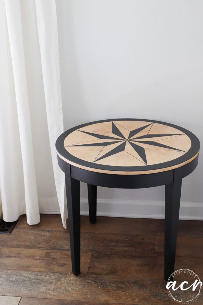 sideview of black and natural table against white wall