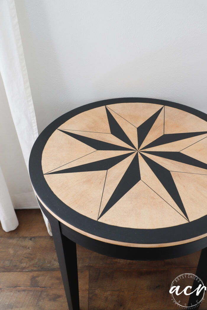 wood and black compass rose table