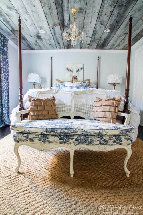 bedroom with bed and bench and gray weathered wood ceiling