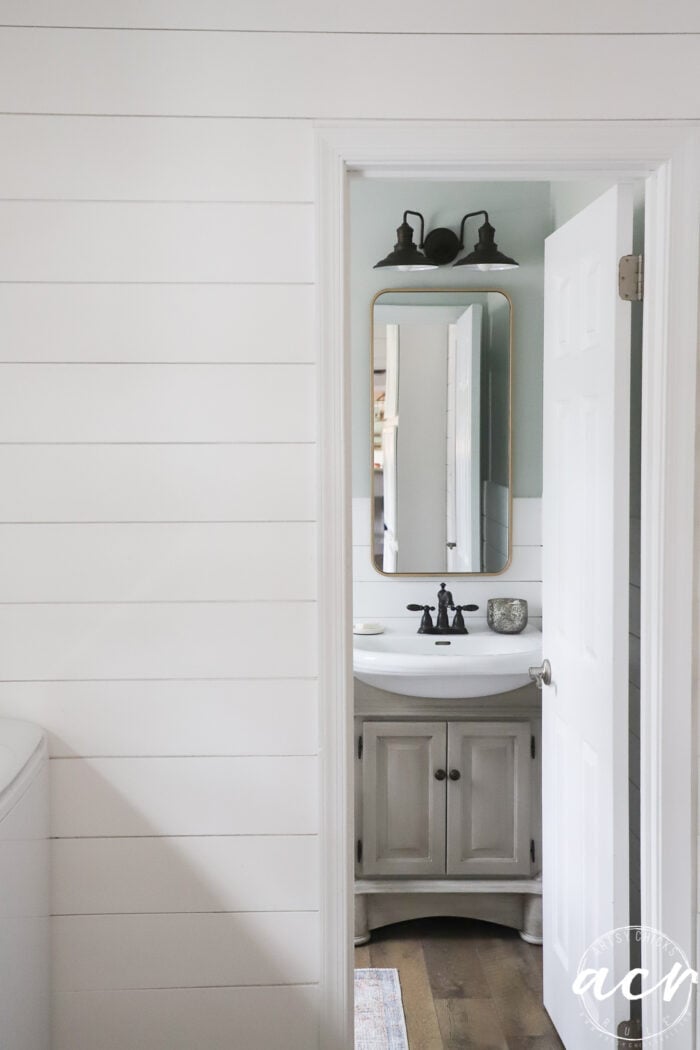 looking into bathroom from laundry room, tan cabinet