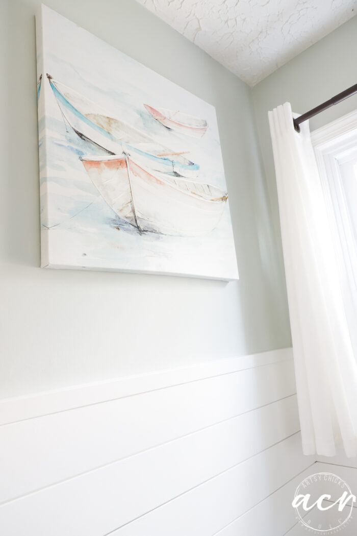 blue green wall with blue and coral sailboat painting
