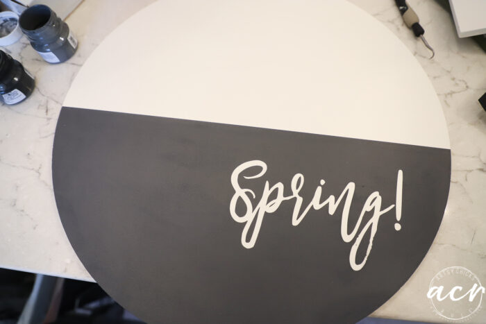 round board half painted black with white letters, spring!