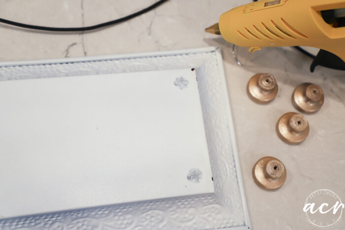 white tray upside down with gold knob feet and glue gun