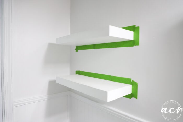 white shelves taped with green tape