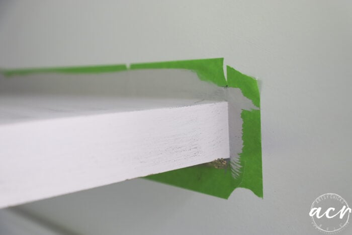 up close of painted shelf and green tape