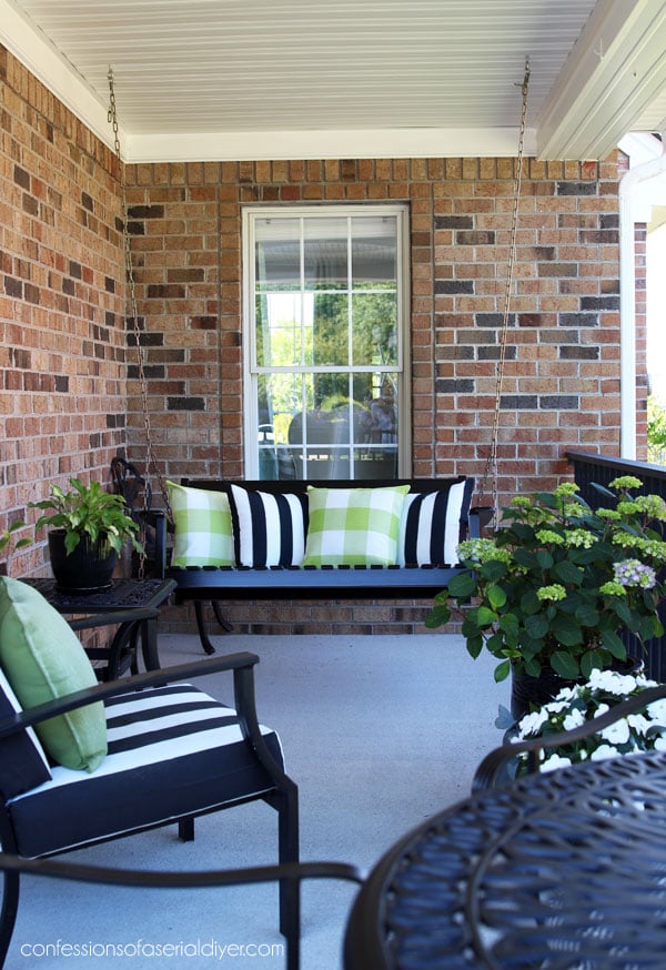 black furniture on porch with black and white and green pillows