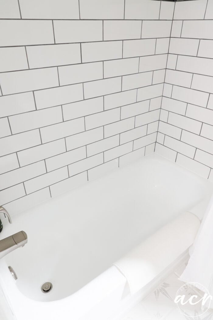 large white subway tile tiled shower and white tub