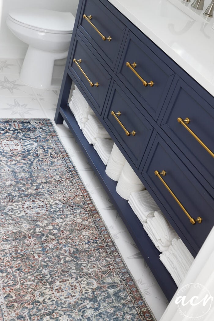 blue vanity, gold pulls, colorful rug