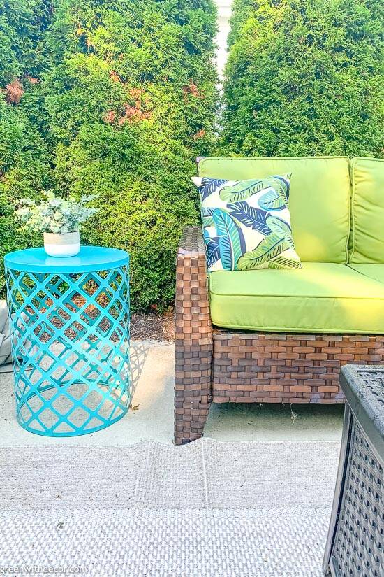green couch cushions outside with turquoise table