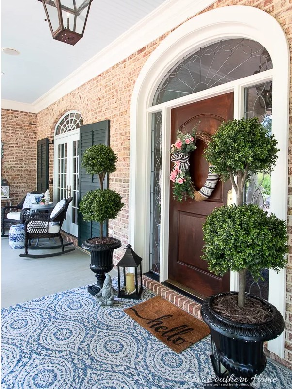 southern style porch with greenery and blue and white rug