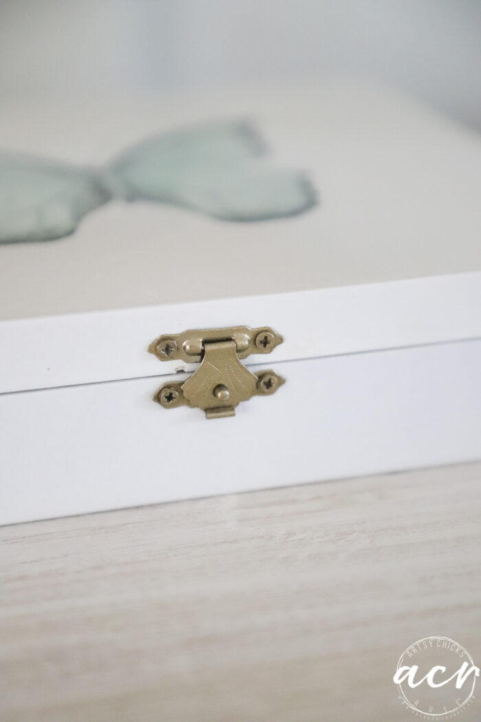 up close of gold hardware on white box