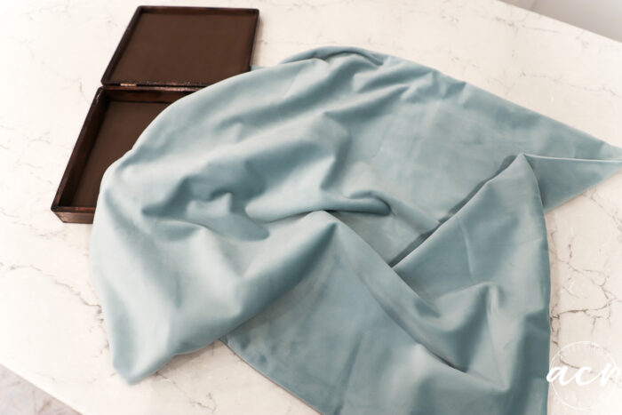 brown box on white counter with aqua fabric