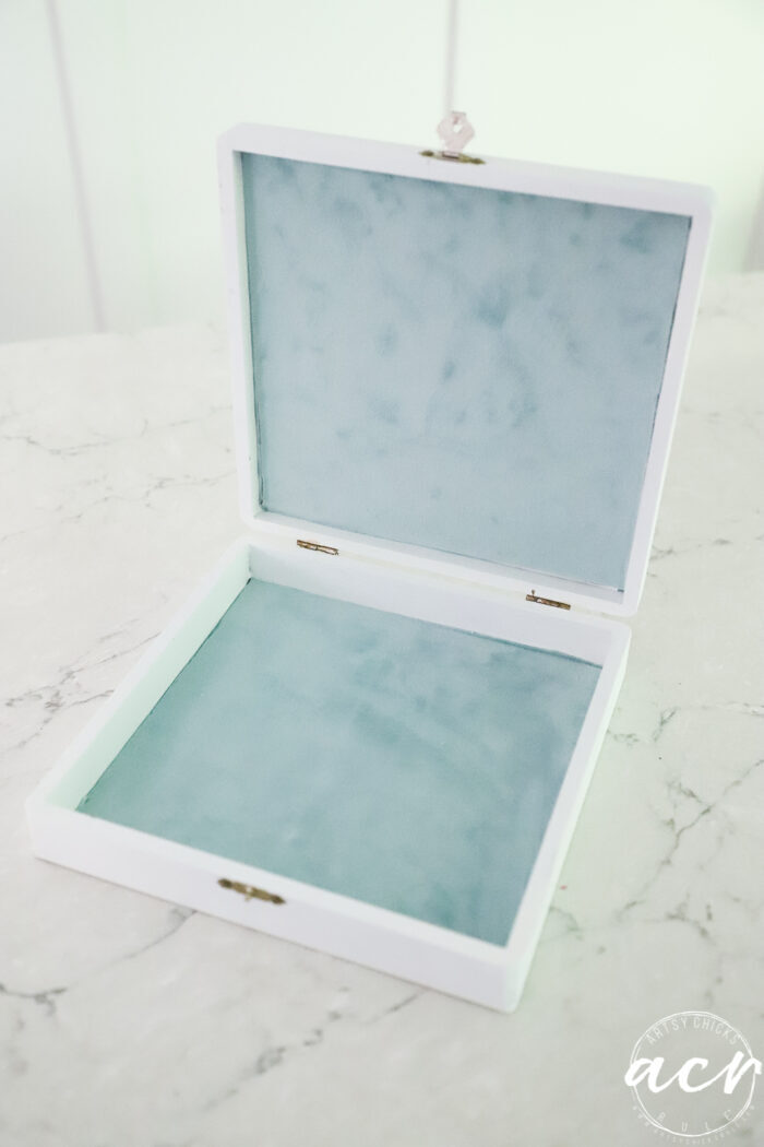 aqua velvet fabric inside white box on white counter
