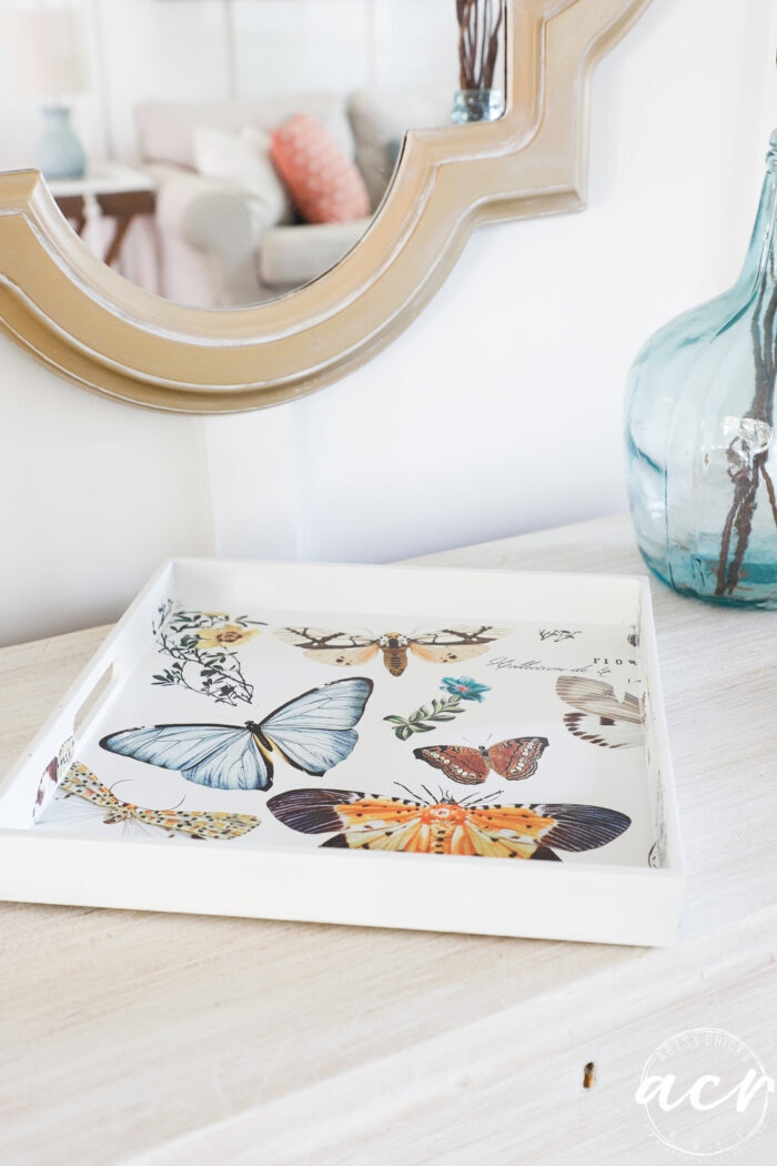 white tray with butterflies on wood dresser