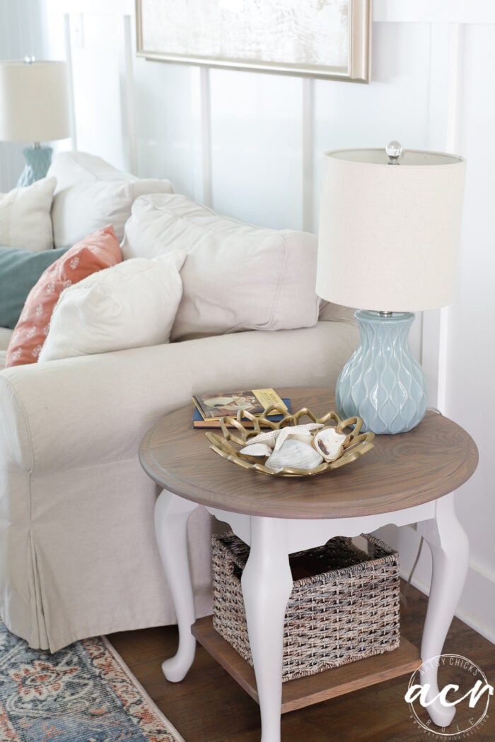 round top side table with wood top and base and beige legs