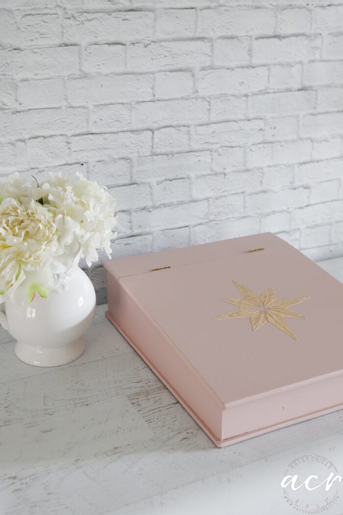 pink box with white flowers beside it
