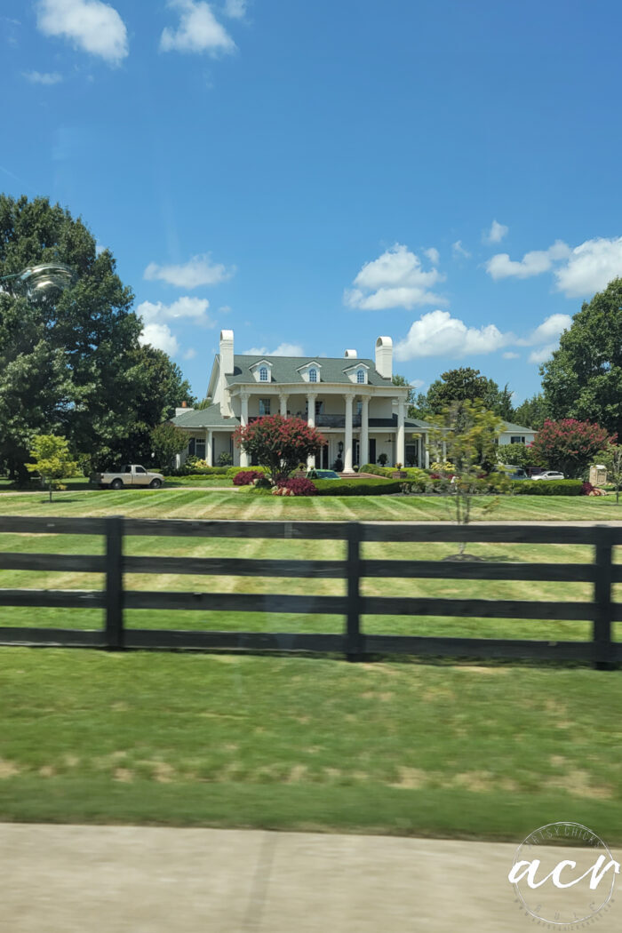 large yard fenced with house with columns