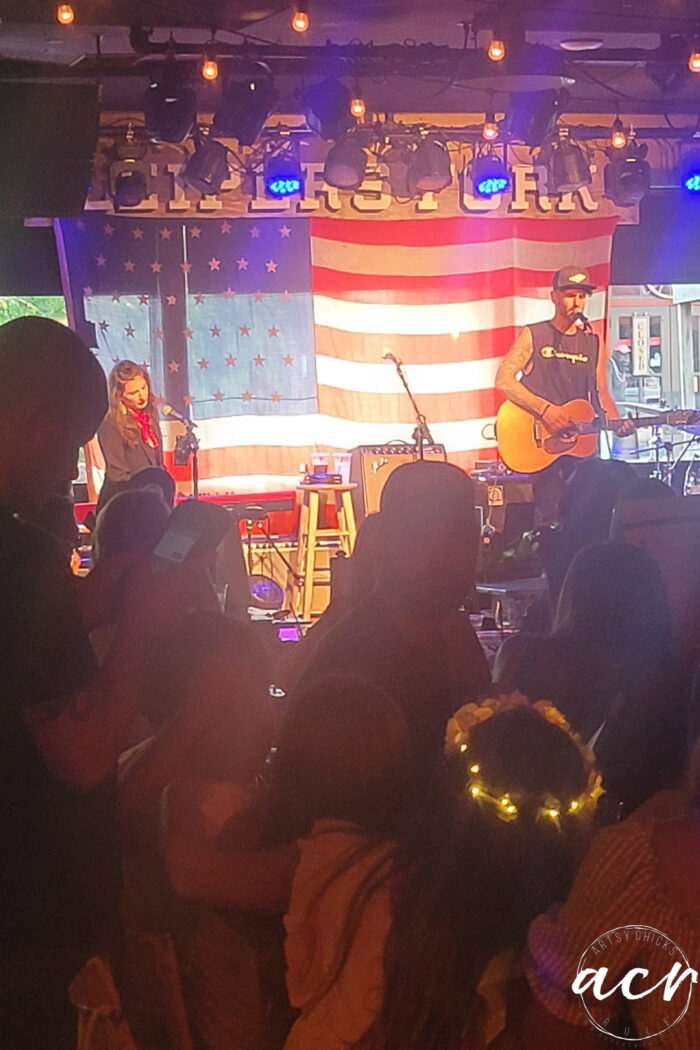 musicians on stage with flag in background