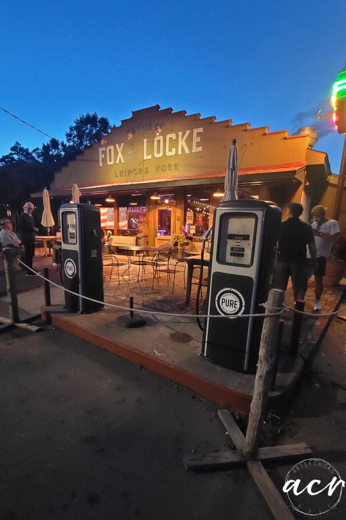 the front of fox & locke at night with old gas pumps