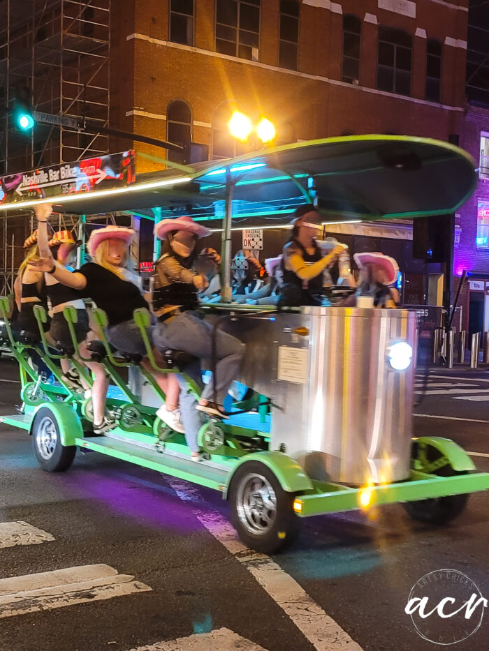 green and purple party vehicle with girls in pink hats