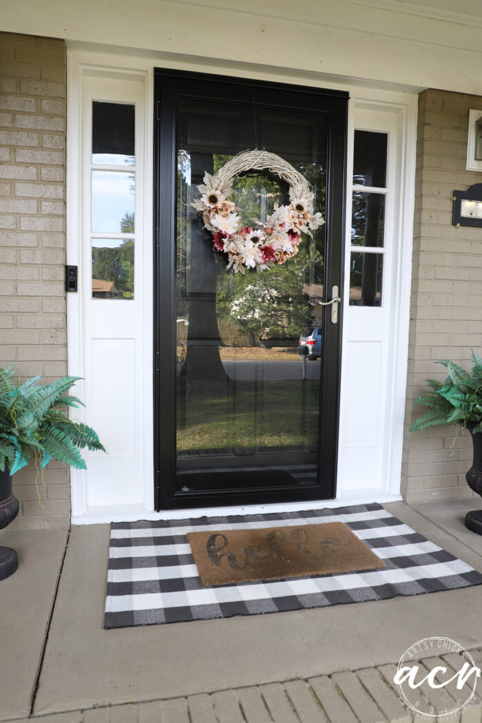 black door white sidelights porch with fall wreath