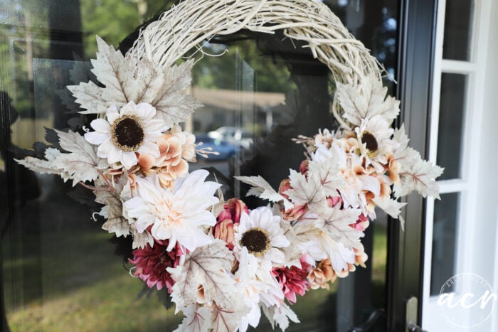 ivory colored grapevine wreath with ivory florals, ivory sunflowers and plum florals