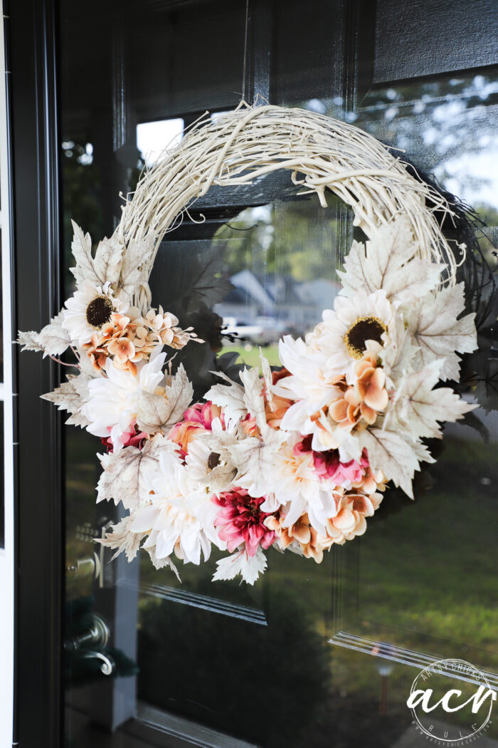 ivory wreath hanging on black door