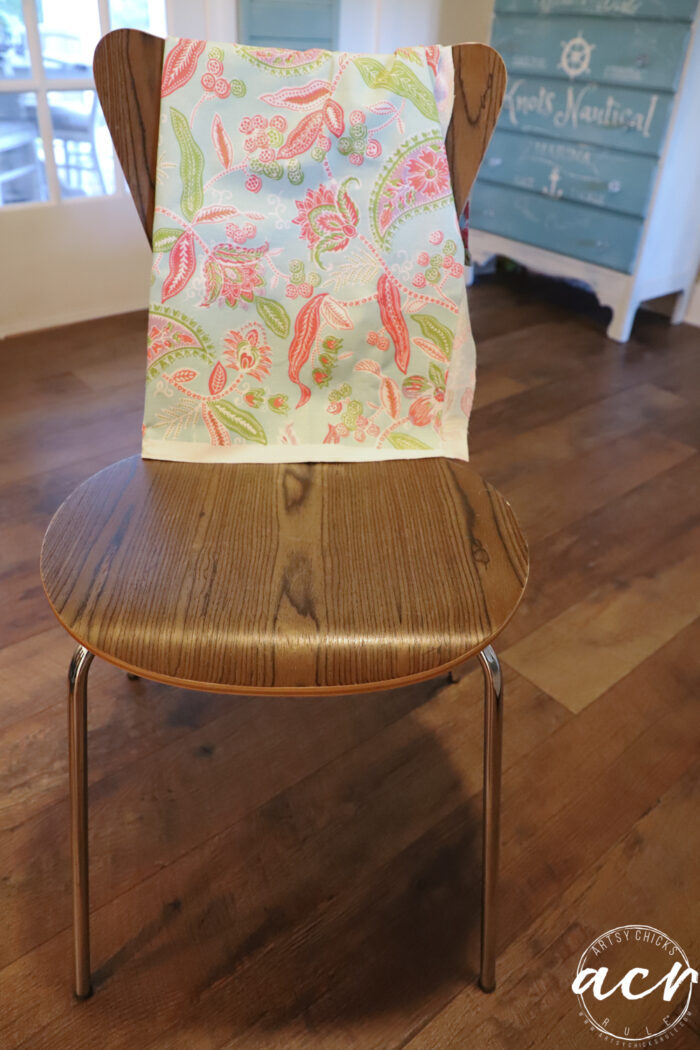 mcm dated chair with pink and green fabric laying over it