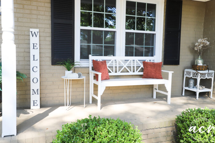 front porch with white bench and white decorated side tables on each side