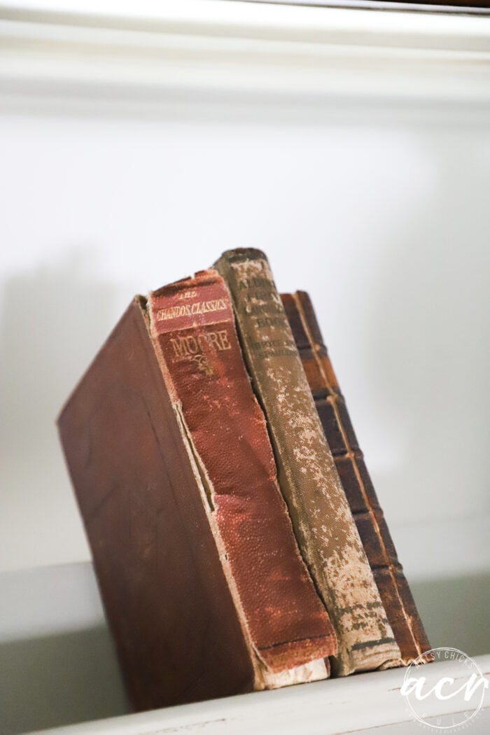 3 very old books on book rack