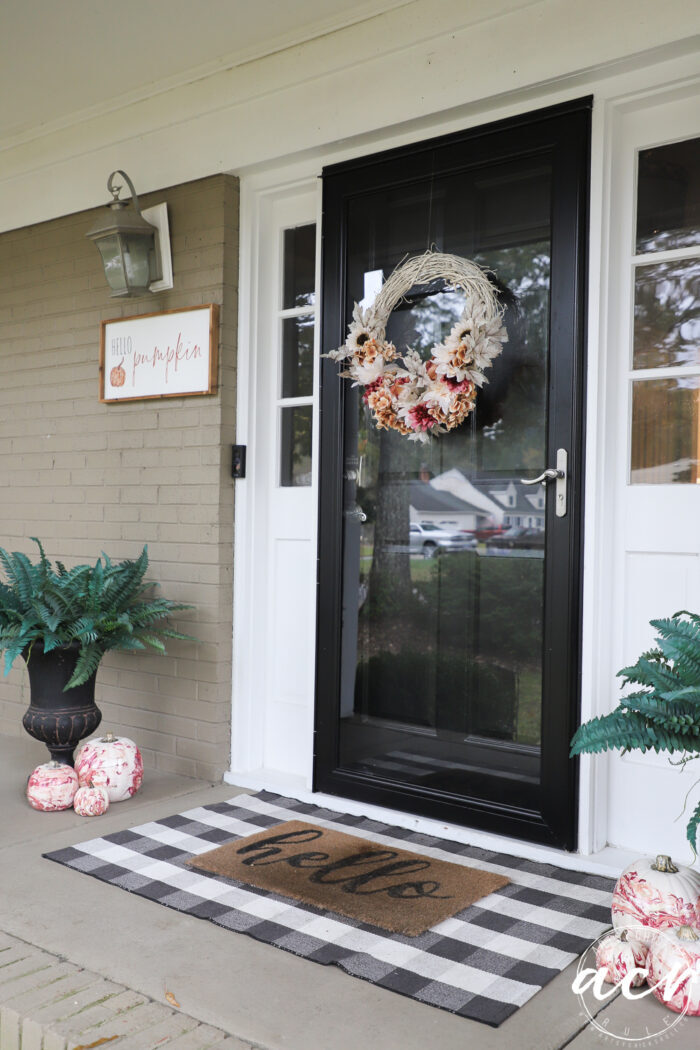 front porch with marbled pumpkins wreath and sign