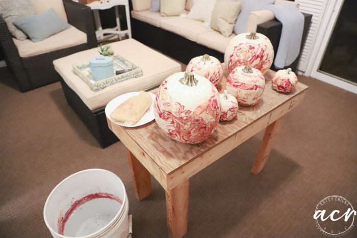 wood table with marbled pumpkins on porch